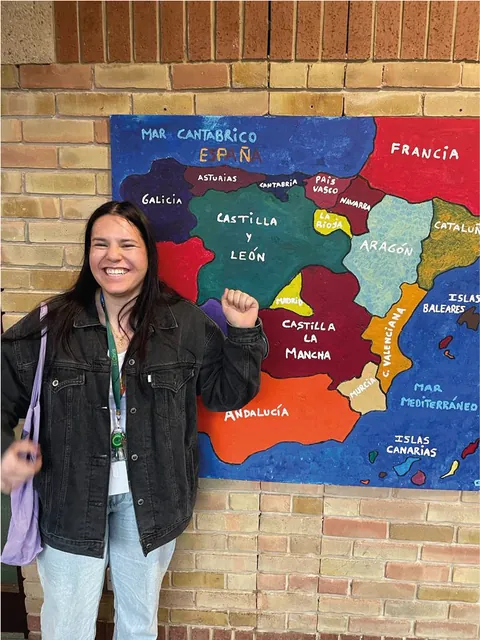 Voluntaria sonriendo junto a un mapa en una sala de idiomas