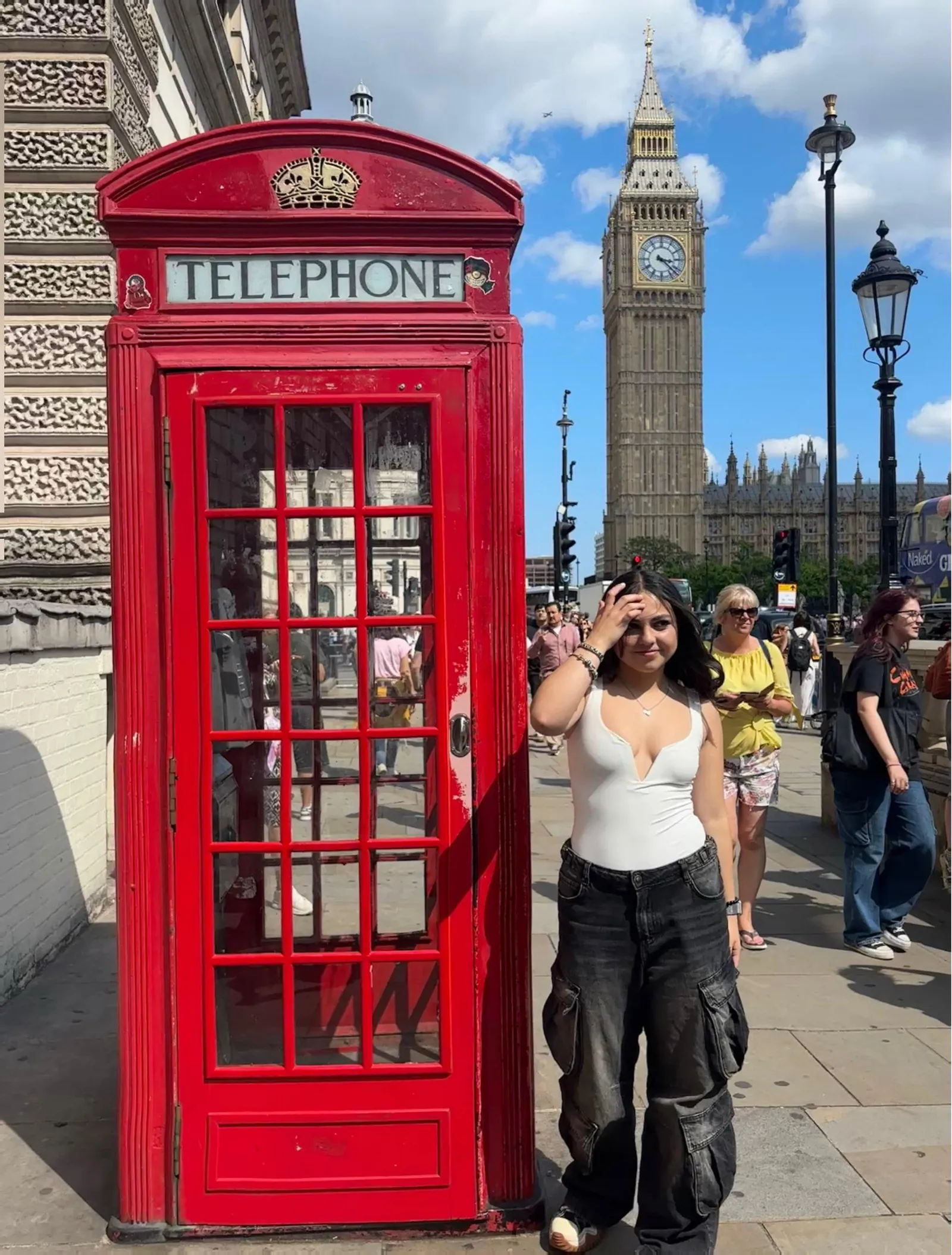 Voluntaria junto a una cabina telefónica roja y el Big Ben en Londres